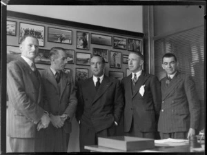 Group portrait at Whites Aviation Office, (L to R) E A Robinson (Whites), G Wells (Tasman Airways), J Mollison, J Harley (Castrol), Leo White (Whites), Auckland City