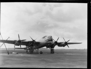 A front view of the Avro Lincoln bomber aircraft Excalibur at Whenuapai Airbase, Auckland, showing an unidentified man standing on a platform working on the propellor