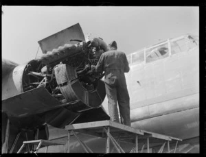 An unidentified man working on a Rolls Royce Merlin engine of a Avro Lincoln bomber aircraft