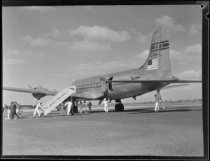 Pan American World Airways Douglas Clipper 'Kit Carson' NC88881, showing ground crew wheeling gangway alongside the aircraft, RNZAF Station, Whenuapai, Auckland