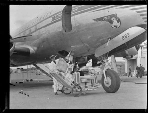An unidentified member of ground crew unloading luggage from Pan American World Airways Clipper 'Malay', location unidentified