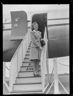 Portrait of Beverley Mogensen, stewardess, Pan American World Airways, on gangway of Clipper aircraft