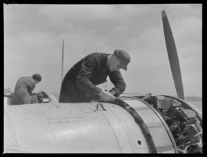 Two unidentified mechanics working on an aeroplane engine, Mechanics Bay, Auckland