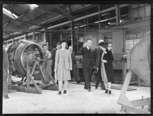 Mrs B Mackenzie, Sir Patrick Duff, Lady Duff, and George Bolt, and other unidentified men, in a workshop, which houses an aeroplane engine