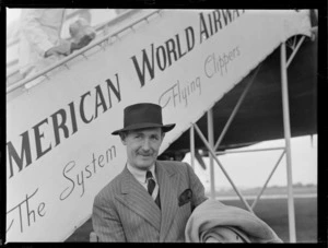 Portrait of Dr A Porrit, Surgeon to the King, in front of a Pan American Airway Clipper Class passenger plane boarding ramp, Whenuapai Airfield, Auckland