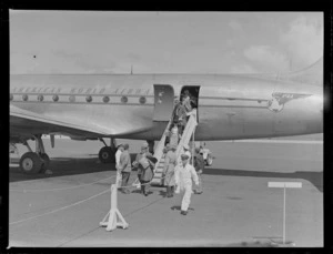 Unidentified ground crew and passengers arriving on Pan American Airways NC-69883 Clipper Class Kathay passenger plane at Whenuapai Airfield, Auckland