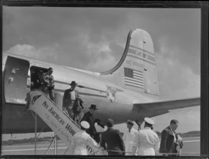 Unidentified ground crew with passenger disembarking PAA NC-8882 Clipper Class Malay passenger plane at Whenuapai Airfield, Auckland