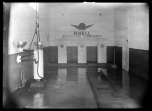 Interior of Shell Oil Company garage, including vehicle oil remover equipment and vehicle lift at Gordons Garage, Wellsford, Rodney district, Auckland