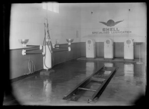 Interior of Shell Oil Company garage, including vehicle oil remover equipment and a vehicle lift at Gordons Garage, Wellsford, Rodney district, Auckland