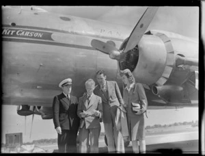 Captain C V George, Mr M Grindle (Port Steward), Mr Q Campbell (Airport Manager) and Mary Lyman (Stewardess) standing next to aircraft PAWA (Pan American World Airways) Clipper Kit Carson