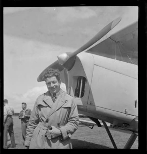 Portrait of photographer H Paton of 'K-20' fame in front of a Tiger Moth bi-plane, location unknown