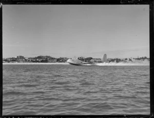 View of the TEAL flying boat Royal Mail Aircraft 'Aotearoa' ZK-AMA taking off from Mechanics Bay, Auckland Harbour