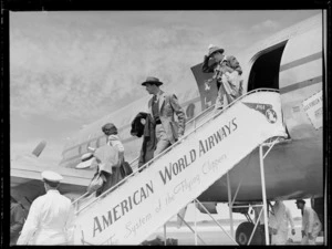 Australian actor John Gaffage (centre) on Pan American Airways plane boarding steps with unidentified man and woman, Whenuapai Airfield, Auckland