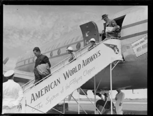 Unidentified passengers disembarking a Pan American Airways Clipper Class plane, Whenuapai Airfield, Auckland