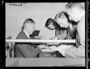 Unidentified PAWA (Pan American World Airways) passengers from America, changing money at the Bank of New Zealand office, at airport