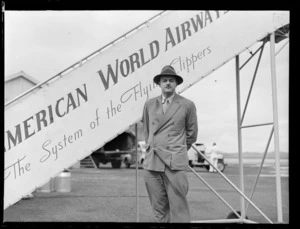 Portrait of Glis Barton, Marine Photographer and Naturalist, in front of Pan American Airways plane boarding steps, Whenuapai Airfield, Auckland