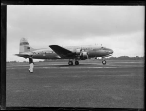Pan American Airways Clipper East India NC88888 aeroplane on the runway with an unidentified man in front, Whenuapai Airfield, Auckland