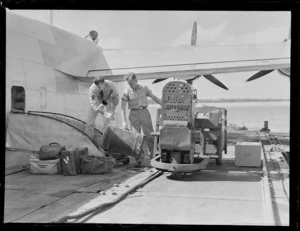Unidentified [airmen?] unloading baggage off an RNZAF Sunderland Flying Boat, Mechanics Bay, Auckland City