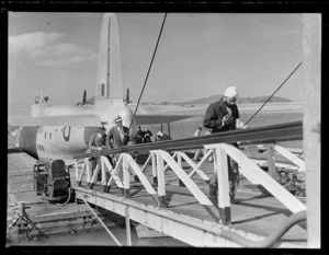 Unidentified passengers on a gangway disembarking an RNZAF Sunderland Flying Boat, Mechanics Bay, Auckland City