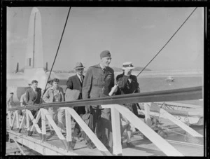 Flight Lieutenant Wilson and other unidentified passengers on a gangway disembarking an RNZAF Sunderland Flying Boat, Mechanics Bay, Auckland City