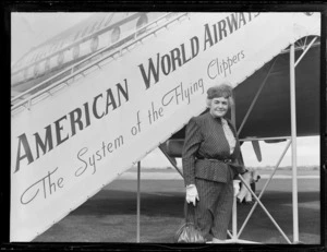 Portrait of Mrs Robinson in front of Pan American Airways plane boarding steps, Whenuapai Airfield, Auckland