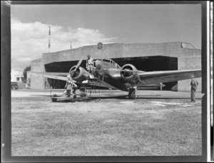 Two unidentified aircraft engineers working on a Lockheed Electra aeroplane 'Kuaka', outside Union Airways hangar, Mangere, Auckland