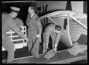 Tasman Empire Airways crew loading sacks of mail onto Short Empire flying boat, before first flight to Sydney