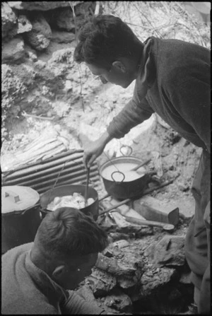 A N Goss at work at an improvised fireplace in the hills near Cassino, Italy, World War II - Photograph taken by George Kaye