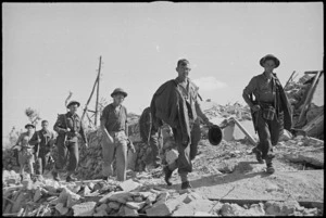 New Zealand infantry advancing through ruins of recently captured town, Italy, World War II - Photograph taken by George Kaye