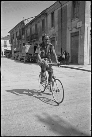D W Smith riding a bicycle in the town of Sora, Italy, World War II - Photograph taken by George Kaye