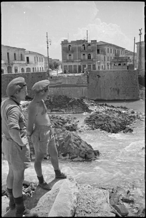 R W Jemison and F J Martin look across a River towards a demolished bridge in Sora, Italy, World War II - Photograph taken by George Kaye