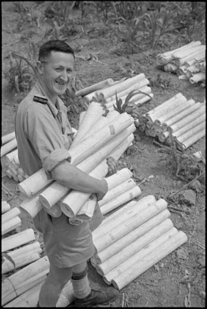 S Mayne busy sorting out the many maps necessary during rapid advance of 2 NZ Division in Italy, World War II - Photograph taken by George Kaye