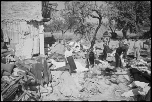 Civilians returning to Orsogna, Italy, dig up their personal clothes and linen after German retreat, World War II - Photograph taken by George Kaye