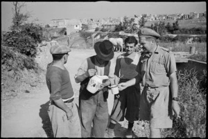 Civilians outside Orsogna, Italy, giving a drink of wine to New Zealand soldier, World War II - Photograph taken by George Kaye