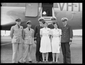Group of unidentified Trans Australia Airlines staff, including stewardesses Betty Park and Margot Umphelby, standing in front of a Douglas Skymaster aeroplane