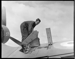 Unidentified man reloading a Corsair aircraft with ammunition, Ohakea, Whanganui District