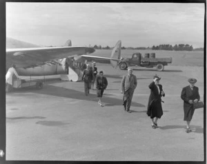 Unidentified passengers leaving a NZNAC (New Zealand National Airways Corporation) aircraft, Palmerston North