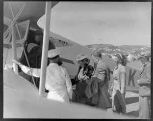 Unidentified passengers boarding a NZNAC (New Zealand National Airways Corporation) Rapide aircraft, Tui, Rongotai, Wellington