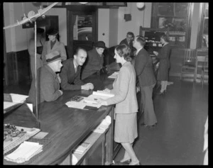 Unidentified NZNAC (New Zealand National Airways Corporation) booking agents booking tickets for unidentified passengers at a Wellington office