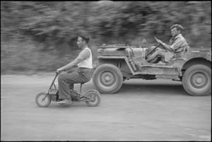 J R Murphy (Dunedin) riding a quaint looking machine at 4 NZ Armoured Brigade sports meeting at Isola del Liri, Italy, World War II - Photograph taken by George Kaye