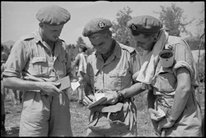 G S Kirk and T McKinnon consult 'Bookie' D J Commons before event at 24 NZ Battalion's boating carnival at Arce, Italy, World War II - Photograph taken by George Kaye