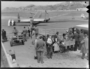 Passengers waiting to embark a New Zealand National Airways Corporation Lockheed Lodestar aeroplane, Rongotai Airport, Wellington