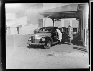 Two unidentified passengers climbing into a Union Airways taxi, Palmerston North Airport, Milson