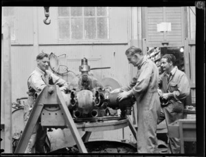 Group of unidentified men dismantling an aircraft engine, New Zealand National Airways Corporation workshop, Milson, Palmerston North