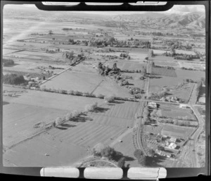 View of farmland with scattered farm buildings, a rail line and roads, Nelson Region