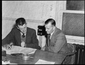 Portrait of Doctor Haskell (PhD) an aerodromes engineer and Bill Lee, at a desk within an unidentified office, Wellington
