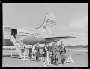 Passengers disembarking from a Pan American World Airways (PAWA), Douglas DC-4 aircraft, Clipper Red Jacket (N88947) at Whenuapai Airbase, Auckland