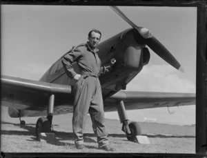 Portrait of Mr Ralph Carter, standing in front of a small aircraft, at Auckland Aero Club, Mangere, Auckland