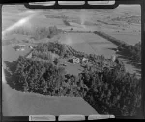 View of an unidentified homestead surrounded by trees and farmland, Timaru District, South Canterbury Region