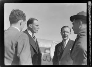 View of (L to R) Pat Castle (Shell Rep) and P Roberts (pilot) with two unidentified men in front of visiting British Vickers Viking passenger plane G-AJJN, location unknown